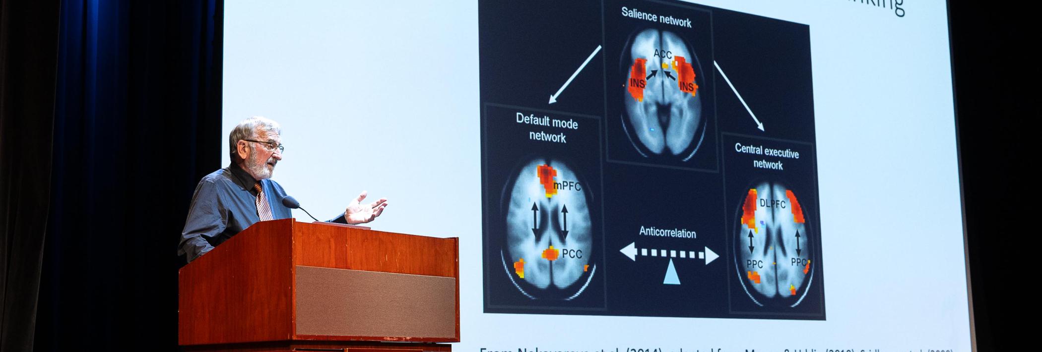 Keith Holyoak presenting slide 5 showcasing brain imaging scans